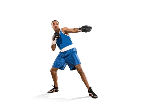 Sporty man during boxing exercises. Photo of boxer on isolated on white background. Strength, attack and motion concept. Fit african american model in movement. Afro muscular athlete in sport uniform