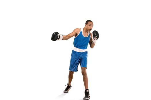 Sporty man during boxing exercises. Photo of boxer on isolated on white background. Strength, attack and motion concept. Fit african american model in movement. Afro muscular athlete in sport uniform