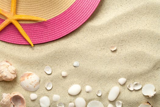 sand background with shells and summer hat. beach texture. copy space. top view