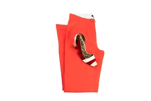 Red elegant woman trousers and an matching elegant female shoe on it.  Fashion concept. Isolated on white.