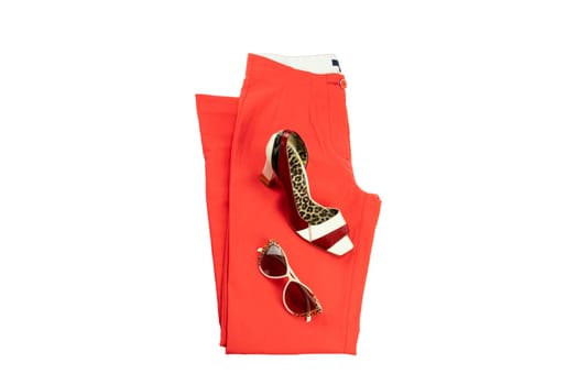 Red elegant woman trousers, an matching elegant female shoe and a fashionable sunglasses on it. Fashion concept. Isolated on white.