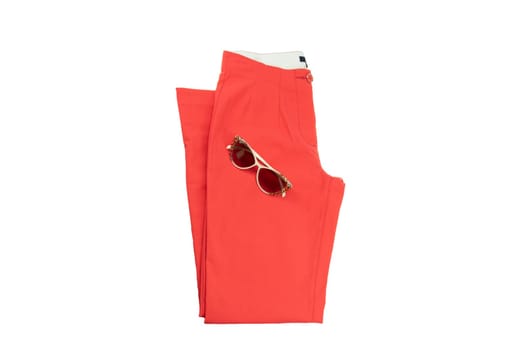 Red elegant woman trousers and a fashionable sunglasses  on it.  Fashion concept. Isolated on white.