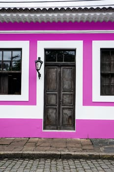 city Morretes Brazil old light chandelier design wooden door glass windows pink wall
