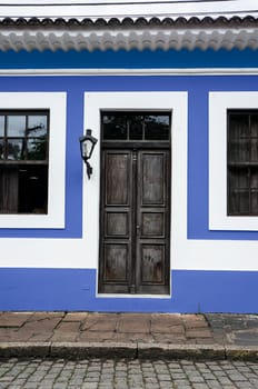city Morretes Brazil old light chandelier design wooden door glass windows blue wall