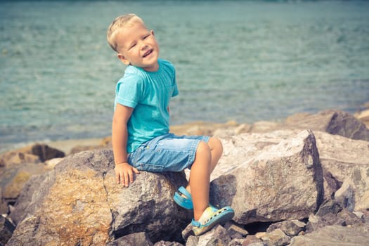 Cute caucasian boy at seaside. Leisure time