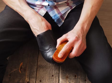Close up of a man cleaning female leather shoes