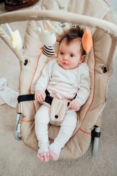 Portrait of a baby girl in her bouncer chair at home.
