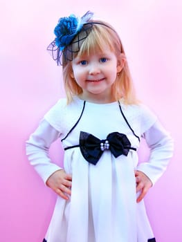 Little girl in fashionable elegant hat smiling and posing on lilac background. Childish fashion. Fashion concept