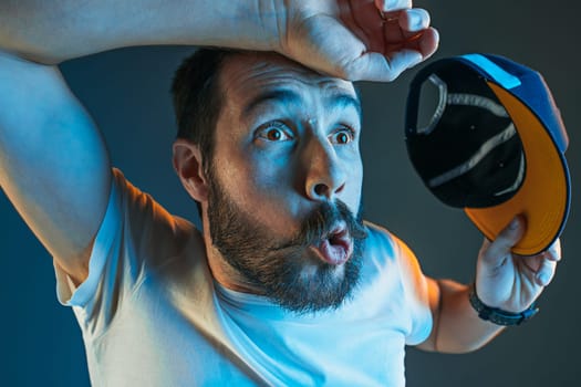 The surprised and screaming man. Hate, rage. Crying emotional angry man in colorful bright lights at studio background. Emotional face. Fan human emotions, facial expression concept.