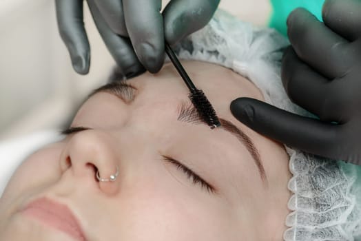 Permanent makeup. Permanent tattooing of eyebrows. Cosmetologist applying permanent make up on eyebrows- eyebrow tattoo