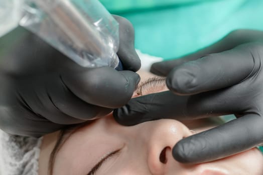 Permanent makeup. Permanent tattooing of eyebrows. Cosmetologist applying permanent make up on eyebrows- eyebrow tattoo