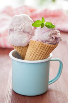 Cream cherry ice cream in waffle cloths in blue cup