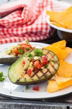 Grilled avocado with vegetables and taco chips