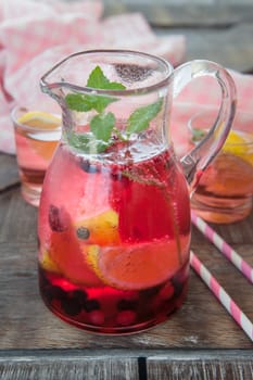 Small jug with colorful lemonade with lemon and mint