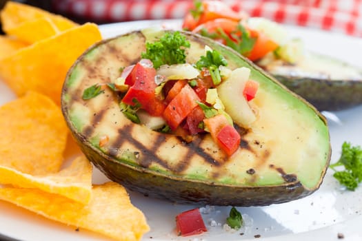 Grilled avocado with vegetables and taco chips