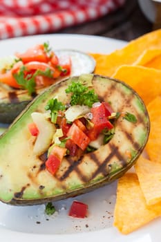 Grilled avocado with vegetables and taco chips