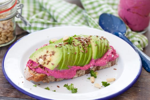 Slice of bread with hummus and fresh avocado