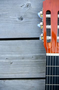 close up of a acoustic guitar neck on wooden ground
