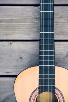 close up of a acoustic guitar on wooden ground