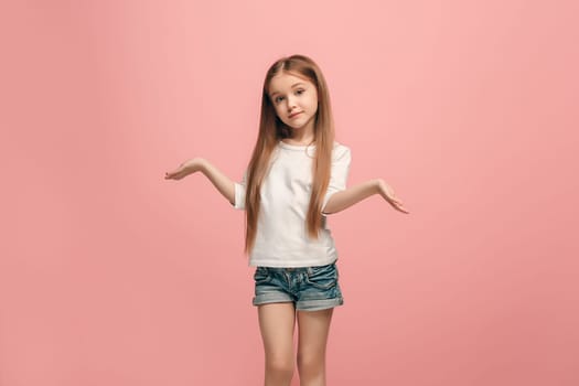 Why is that. Beautiful female half-length portrait on trendy pink studio backgroud. Young emotional surprised, frustrated and bewildered teen girl. Human emotions, facial expression concept.