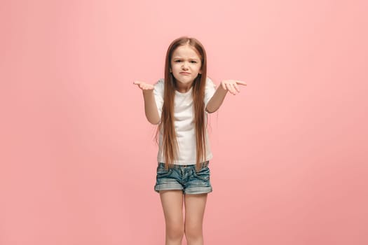 Why is that. Beautiful female half-length portrait on trendy pink studio backgroud. Young emotional surprised, frustrated and bewildered teen girl. Human emotions, facial expression concept.