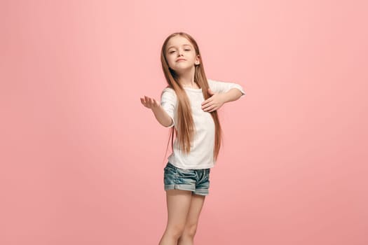 Happy teen girl standing, smiling isolated on trendy pink studio background. Beautiful female half-length portrait. Young satisfy girl. Human emotions, facial expression concept. Front view.