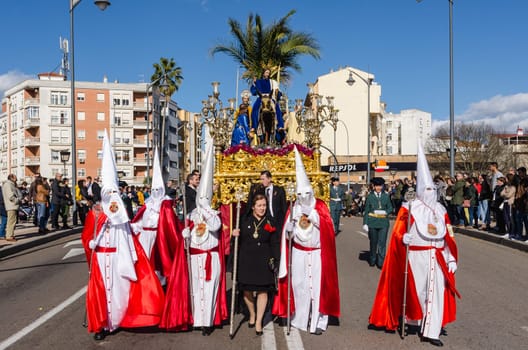 BADAJOZ, SPAIN - MARCH 26, 2018: Nazarenes and Jesus riding a donkey, during the celebration of Palm Sunday.