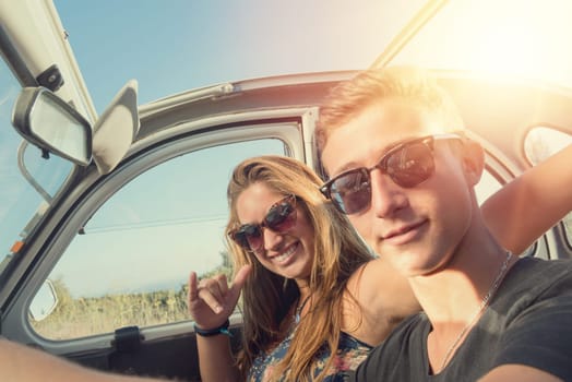 Young couple in a retro car at sunset, retro style.