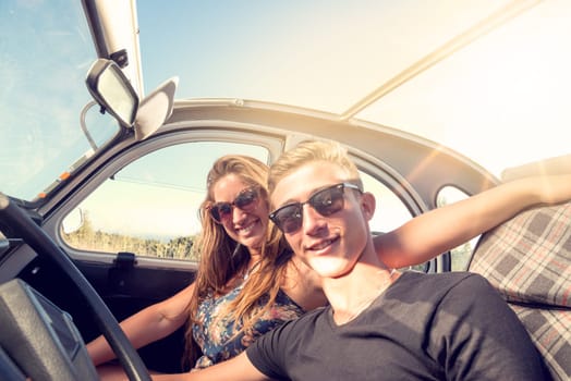 Young couple in a retro car at sunset, retro style.
