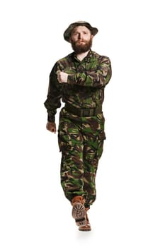 Young army soldier wearing camouflage uniform going isolated on white studio background in full-length. Young caucasian model. Military, soldier, army concept. Proffeshional concepts