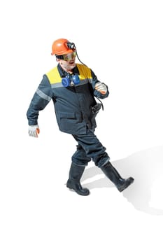The studio shot of senior bearded serious male miner in professional helmet going at the camera isolated on a white studio background. Woker and industry concept. Mature caucasian model