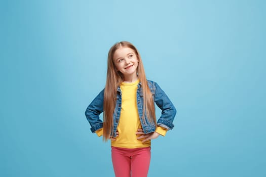 Happy teen girl standing, smiling isolated on trendy pink studio background. Beautiful female half-length portrait. Human emotions, facial expression concept.