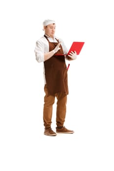 Surprised butcher posing with a laptop isolated on white studio background. The young caucasian male model in full-length. Butcher, professional concept
