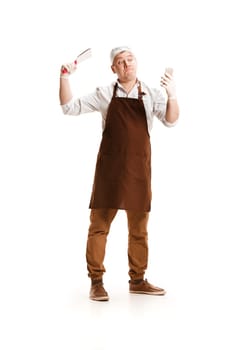 Smiling butcher posing with a knife and mobile phone isolated on white studio background. The young caucasian male model in full-length. Butcher, knife, professional concept