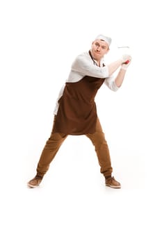 Angry aggressive butcher swinging with a knife isolated on white studio background. The young caucasian male model in full-length. Butcher, knife, professional concept
