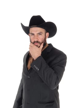 A young serious looking man in a gray blazer and black cowboy hat.with one hand on his beard, isolated for white background.