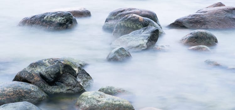Marine stones washed by a wave, close up