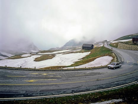 Fogy Alpine road with traffic in  Austria