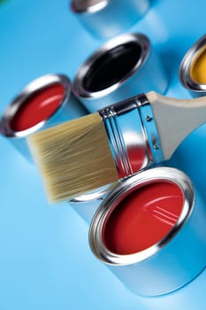 Paintbrush on cans with color