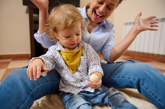 A joyful mother enjoys bonding with her young child while playing together at home, emphasizing the warmth of parental love and family connection.