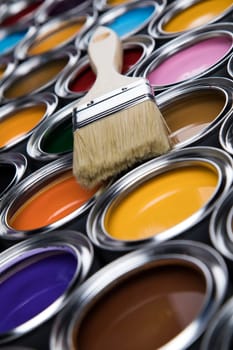Paintbrush on cans with color