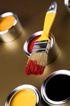 Paintbrush on cans with color