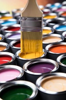 Tin cans with paint, brushes and bright palette of colors