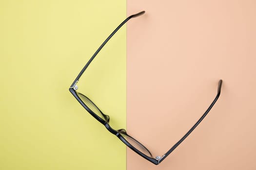 black glasses on yellow and orange ground from above