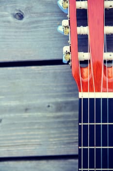 close up of a acoustic guitar neck on wooden ground