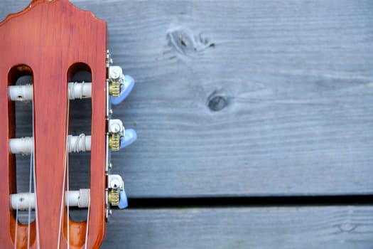close up of a acoustic guitar neck on wooden ground