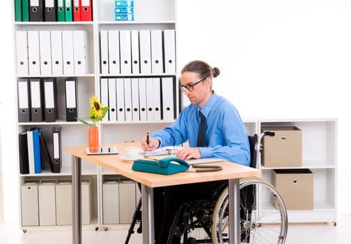 disabled business man in wheelchair is writing