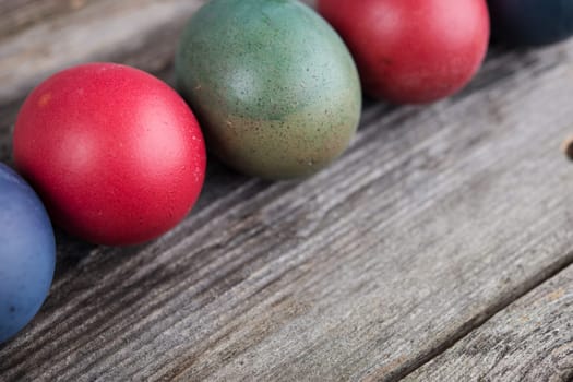 line of different easter eggs on gray wooden ground