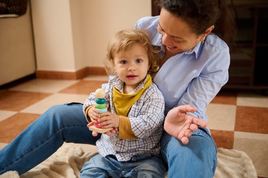 A joyful mother engages with her young child, fostering affection and bonding while enjoying quality time at home.
