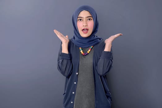 Cheerful asian muslim woman with happy expression against dark background